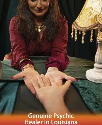 In a softly lit room, an experienced guide gently reads an open palm, creating a serene connection. The warmth of her gaze and the inviting glow of the lamp offer comfort and assurance, fostering a deep sense of trust. Genuine psychic healer in Louisiana.