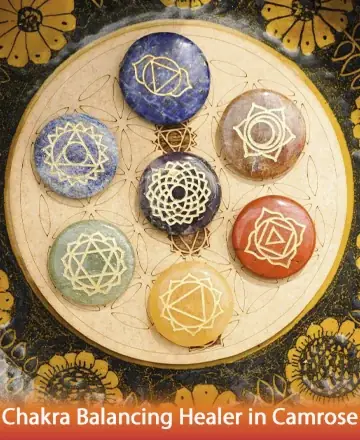 In a serene embrace of colors, the image reveals intricately designed chakra stones resting harmoniously on a sacred mandala. Each stone radiates tranquility and balance, inviting a gentle connection to inner peace and spiritual alignment. Chakra balancing healer in Camrose.